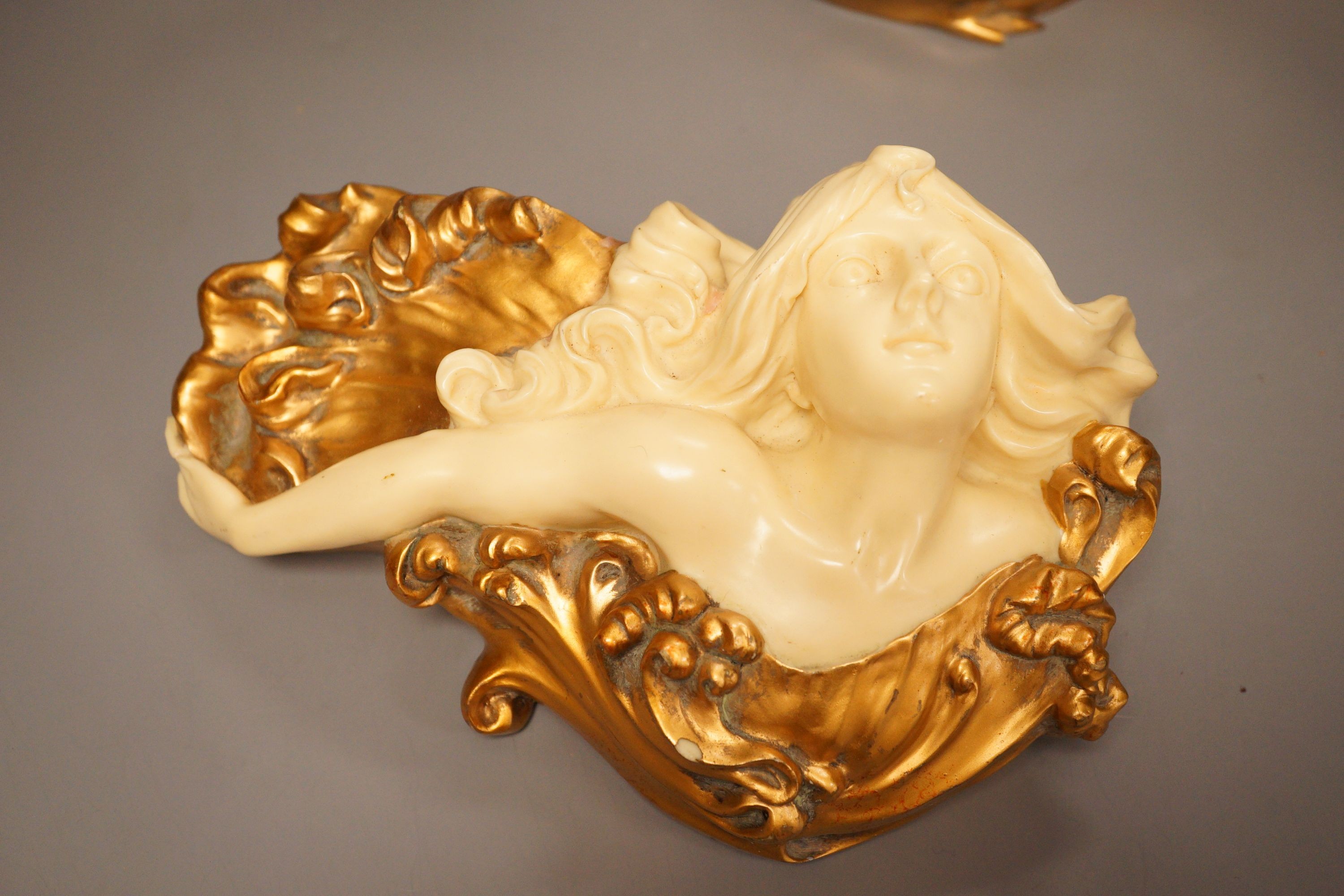 A pair of gilt resin figural wall appliques, signed, and a 19th century cast iron and slate beaker, Sotheby’s label to base, tallest 17cm